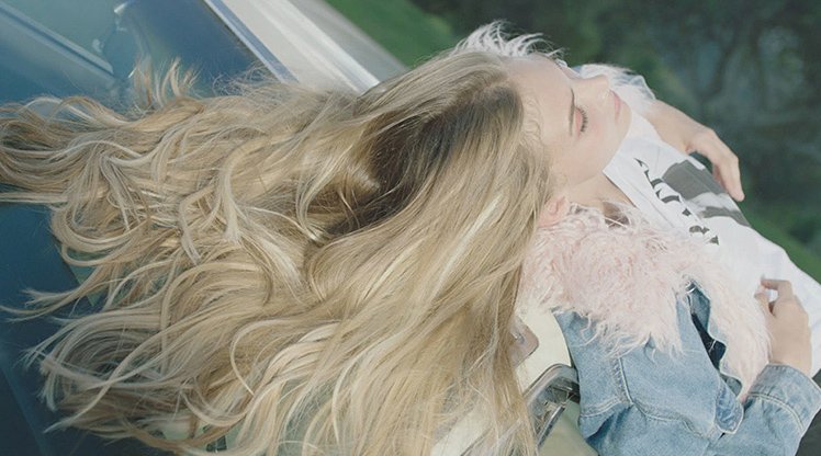 Frau mit üppigen langen blonden Haaren